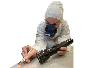Asbestos analyst in mask and coverall with torch