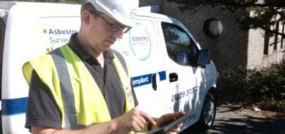 Asbestos consultant with tablet and van