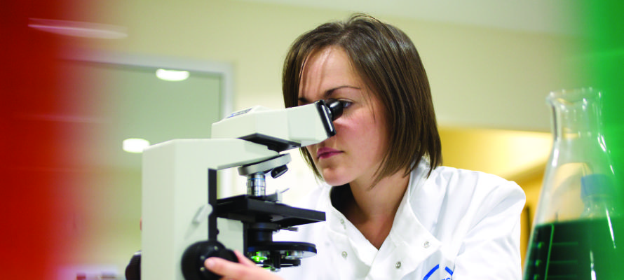 Asbestos analyst looking into a microscope