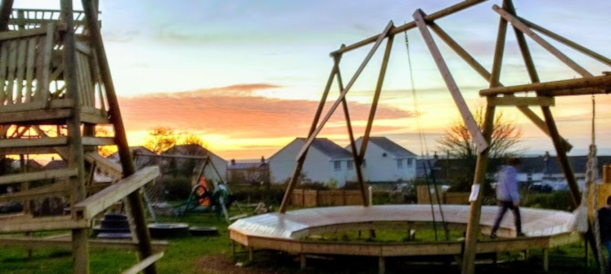 Gwelan Tops Adventure Playground Children playing at Gwealan Tops Adventure Playground with a sunset.