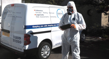 Asbestos surveyor in PPE by van